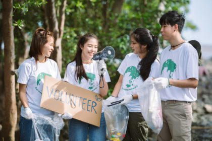 Group of volunteers hold a volunteer sign in world environment day event, volunteer conservation.